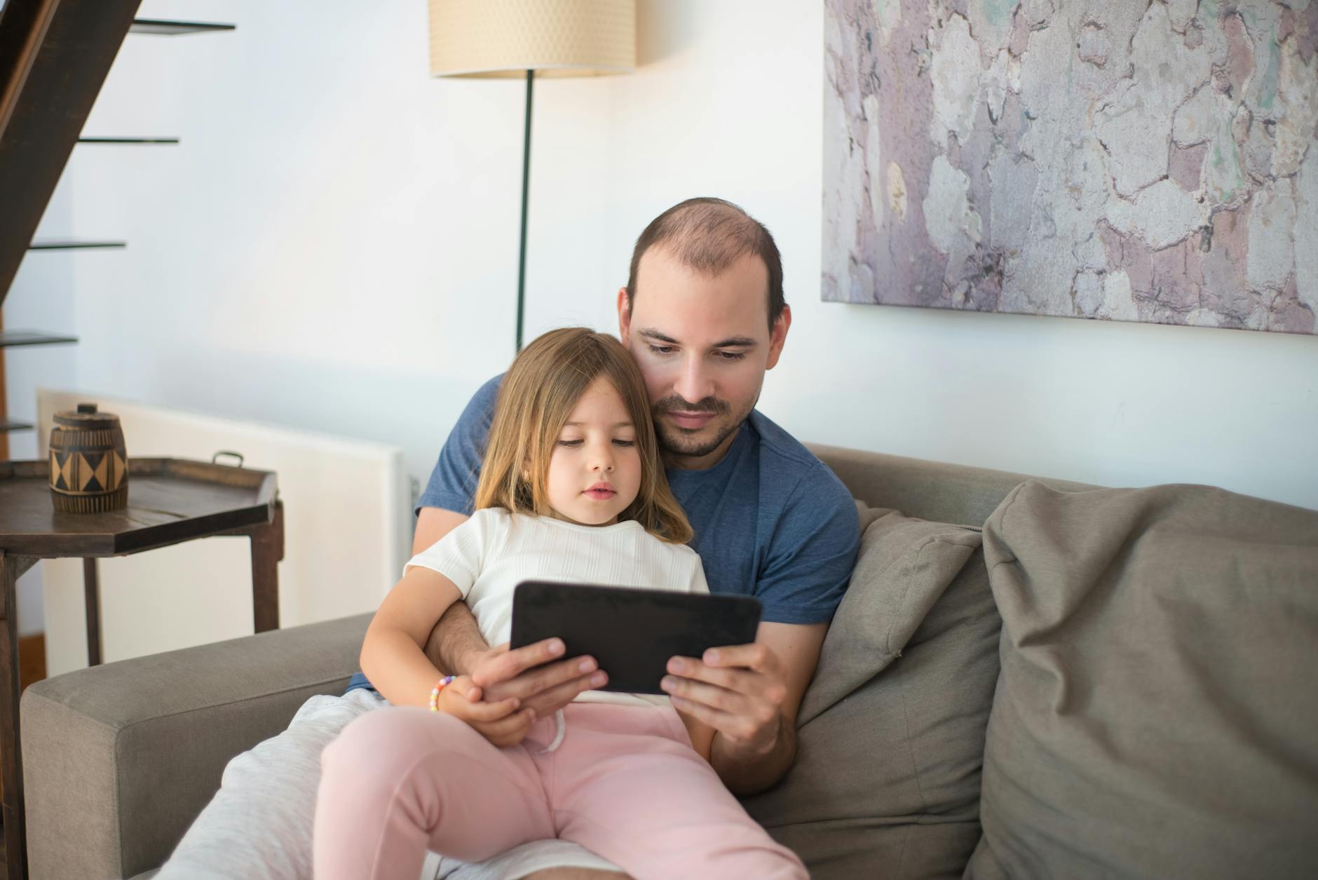 a father and daughter using a tablet together